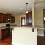 Gourmet Kitchen with granite countertops, stainless steel appliances, hardwood floors, and elegant cabinetry